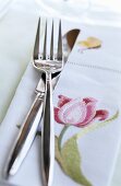 Cutlery and a napkin with a flower motif