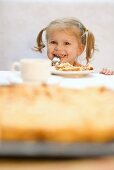 Kleines Mädchen isst Quittenkuchen