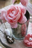 A pink faux rose and a crocheted flower as table decoration