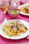 Salmon strips on a bed of fried potatoes