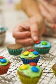 Decorating chocolate cupcakes with chocolate beans