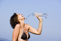 Junge Frau erfrischt sich mit Wasser