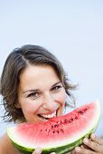 Young woman eating a slice of watermelon