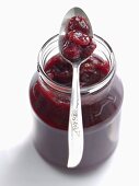 Cherry and kumquat jam in jar with spoon