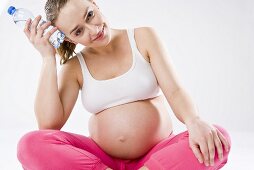 Pregnant woman with bottle of water in her hand