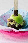 Chocolate-coated green apple with dried fruit for children