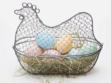 Easter eggs on hay in wire basket