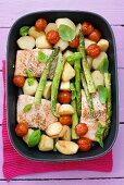 Salmon, potatoes, asparagus & cherry tomatoes in roasting dish
