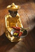 Gilded statuette with dried chillies