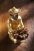 Gilded statuette with a bowl of star anise