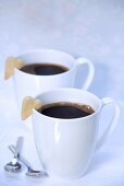 Zwei Tassen schwarzer Kaffee mit Herzkeksen