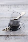 A small glass of balsamic vinegar on a fork