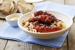 Sausages on onions with bread and mustard