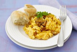 Scrambled egg with chanterelles and a bread roll