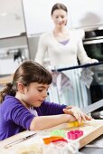 Mother and daughter baking biscuits