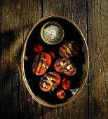 Gegrillte Tomaten in einem Körbchen mit Salz
