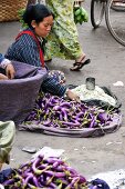Frau verkauft Auberginen auf einem Markt in Burma