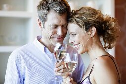 Couple clinking glasses of white wine