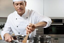 Chef stirring the contents of a frying pan