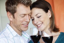 Courting couple clinking glasses of red wine