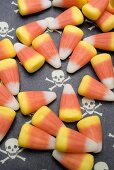 Candy corn on patterned background (skulls and crossbones)