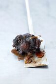A piece of braised oxtail on a spatula