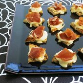 Warm canapés with Vacherin cheese and prosciutto