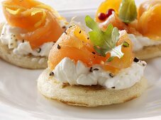 Blinis topped with soft cheese, smoked salmon and rocket