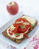 Wholegrain bread topped with hummus (chick-pea spread) & tomatoes