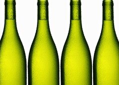 White wine in four green bottles