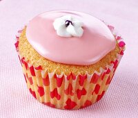 Cupcake with pink icing and white sugar flower