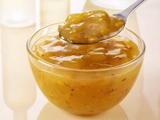Spicy orange sauce in glass bowl and on spoon