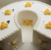 A white cake with yellow sugar roses