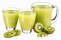 Kiwi fruit juice in jug and two glasses & fresh kiwi fruit