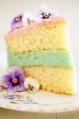 Piece of cake with coloured filling and pansies