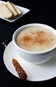 Caffè latte with sugar swizzle stick and biscotti
