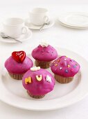 Vier Muffins mit pinkfarbenem Zuckerguss zum Muttertag