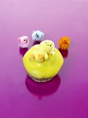 Muffin mit gelbem Zuckerguss und Fruchtgummi-Küken zu Ostern