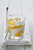 Yoghurt with peach and hazelnuts in glass