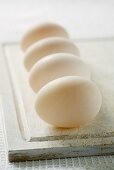 Four duck eggs on chopping board