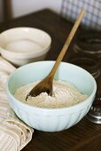 Flour and wooden spoon in mixing bowl