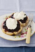 Scones topped with jam and clotted cream