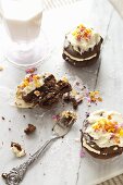 Chocolate whoopie pies with cream and sugar stars, one with a bite taken out and a glass of milk