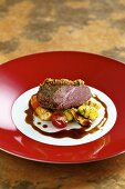 Saddle of lamb with an olive crust with artichoke and gnocchi