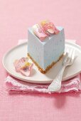 A slice of blue cheese cake with rose petals