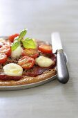 Pizza with bran, minced meat, mozzarella and cherry tomatoes