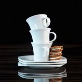 A stack of espresso cups with three espresso biscuits