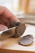 A black truffle being sliced