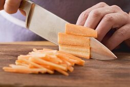 carrots being cut into fine strips