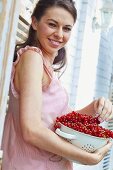 Young woman with fresh red currants